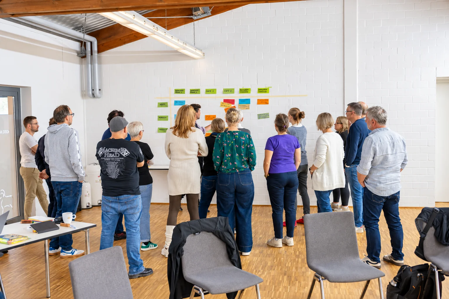 Teilnehmende arbeiten gemeinsam an der Themenwand