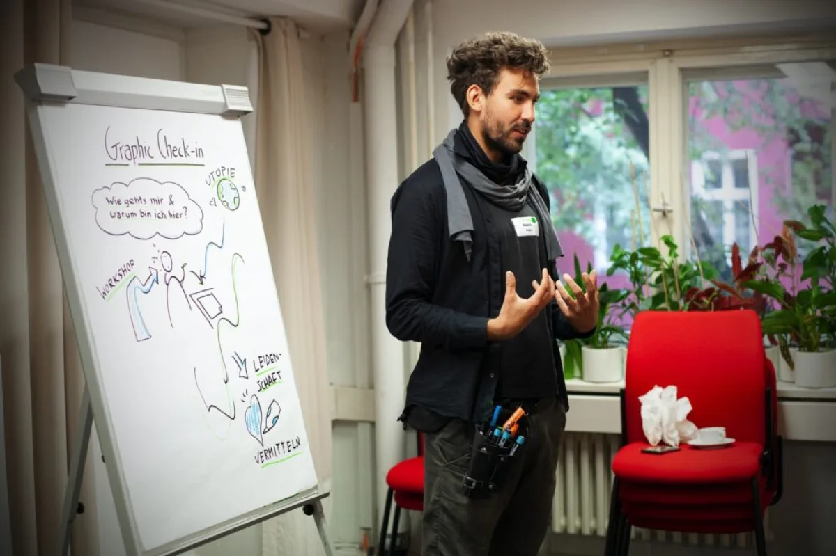 Robin Hotz spricht bei einem Symposium vor einer visuellen Präsentation